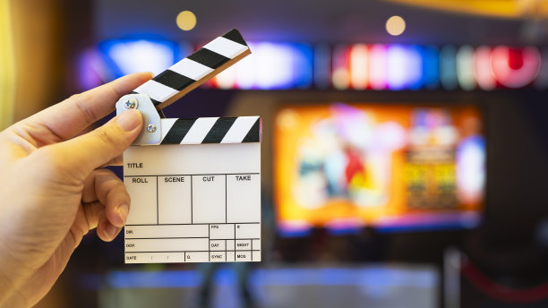 一个人在电影院前伸手去拍电影，一张关于电影、戏剧、看电影的商业概念的图片。图片下载