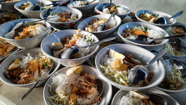 温馨的公共用餐场景，碗里装满了芳香的米饭，装饰着各种各样的浇头图片下载