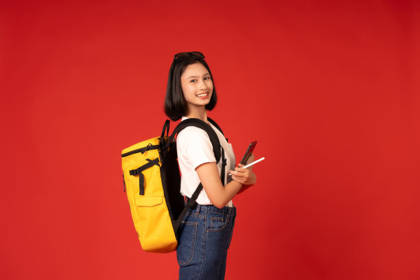 工作室照片中明亮的红色背景突出了亚洲女学生对教育的执着，色彩的对比为她的学术和专业形象增添了戏剧性的效果。图片下载