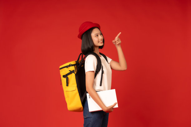 作为一名女学生，她在一个有着醒目红色背景的工作室里学习，反映了她对学习的奉献精神，她的教育为她的愿望和抱负铺平了道路。带着书包和书。图片下载