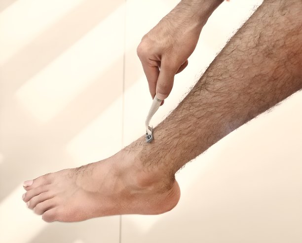 在白色背景中，手拿剃刀剃腿毛图片下载
