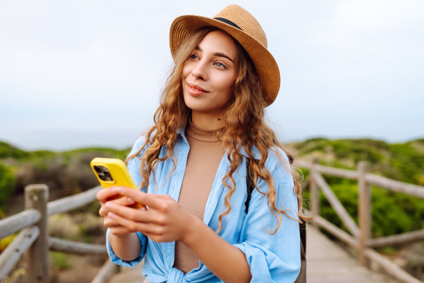 快乐的女人——带着手机欣赏美景的游客。图片下载