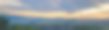 全景美景与蓝天。春天的夕阳在村庄上空。有田野和山脉的乡村景观。照片的背景是村庄的景色和阳光。图片下载