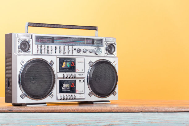 Boombox收音机立体声盒式录音机上的老式木架子前黄色背景。复古的老式滤镜照片图片下载