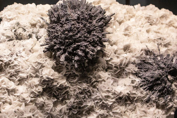 黑白相间的石头，黑色背景上的针。矿物石材壁纸。未经抛光的原始宝石纹理水平特写照片。Sulfosalt图片下载