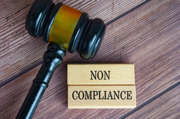 不合规文本的顶视图雕刻在木块与律师小木槌背景。法律与合规概念。图片下载