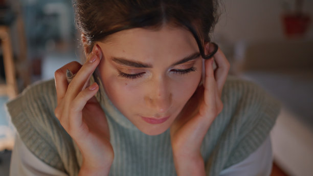 压力大的女孩晚上在工作场所按摩头部特写。疲惫的学生工作图片下载