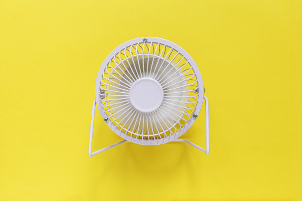 黄色背景上的金属迷你风扇。散热和通风图片下载