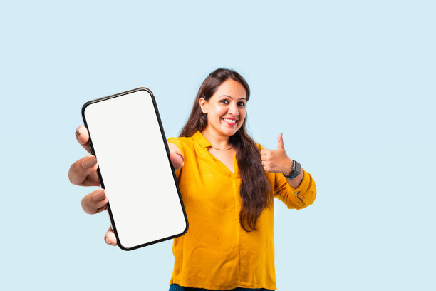 印度亚裔年轻女子展示了空屏幕的大智能手机图片下载