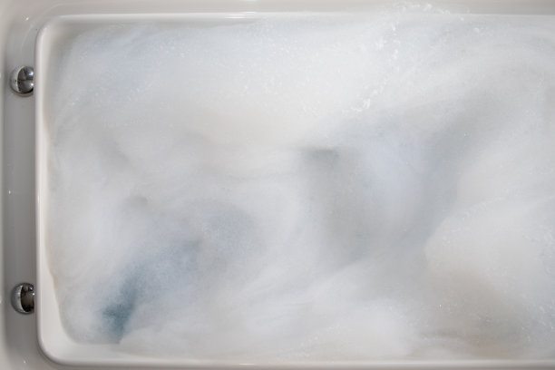 按摩浴缸里的白色泡泡是为度假村舒适客房里的私人按摩浴缸准备的泡泡。大量的小气泡背景和复制空间插入文本。图片下载