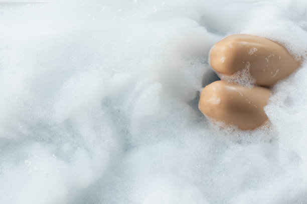 女子在豪华度假村为客人提供的按摩浴缸服务中浸泡肥皂矿泉水。这位年轻女子正在独自享受按摩浴缸放松和漩涡按摩。图片下载