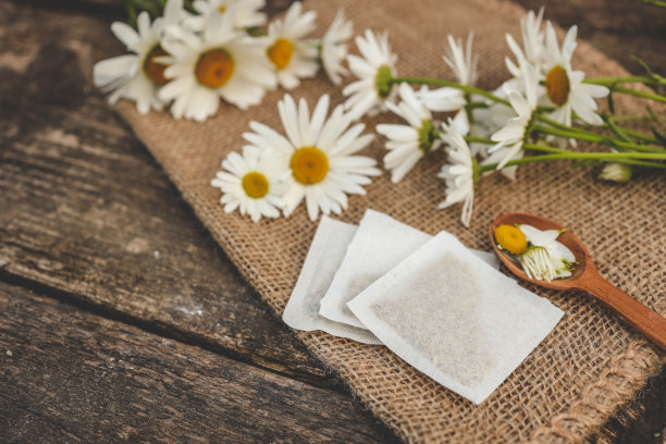 一包洋甘菊茶。装在木质背景袋里的洋甘菊茶图片下载