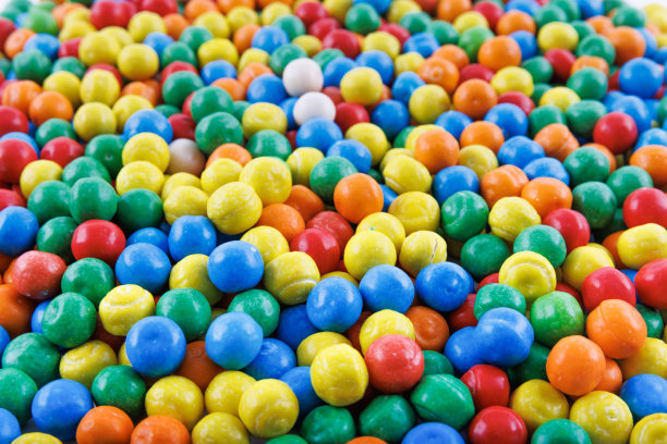五颜六色的背景，各色闪亮的圆形口香糖球。彩色口香糖的背景照片。很多口香糖糖果。糖果专卖店内的糖果照片。图片下载