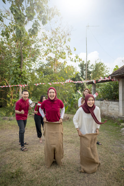 一群人正在玩麻袋赛跑游戏图片下载