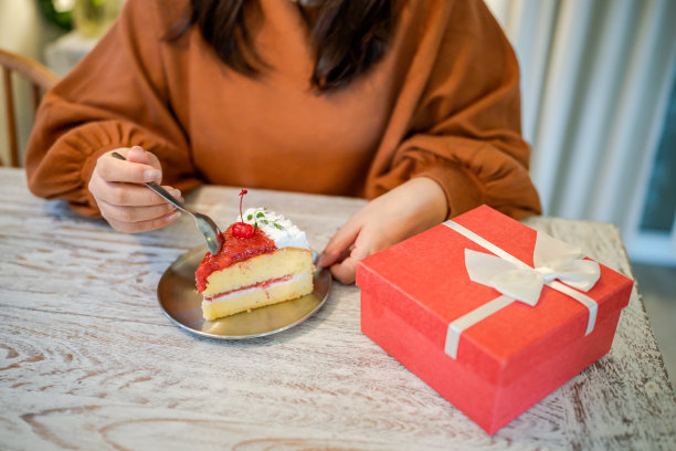 快乐的亚洲妇女吃美味的圣诞fruitÂ蛋糕。圣诞晚餐派对配上美味的圣诞蛋糕，有新年和圣诞的概念图片下载