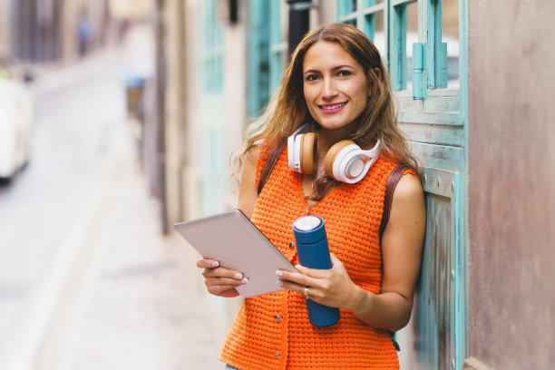 女子手持可重复使用的水瓶使用数码平板电脑图片下载