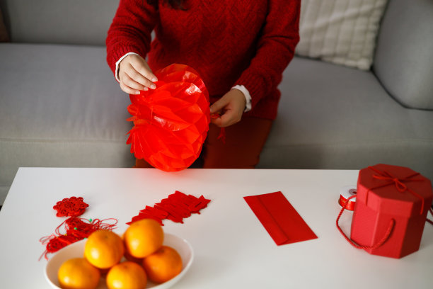 亚洲妇女穿着红色的衣服，制作纸工艺，红色的中国新年灯笼或农历新年装饰，中国新年庆祝活动好运图片下载