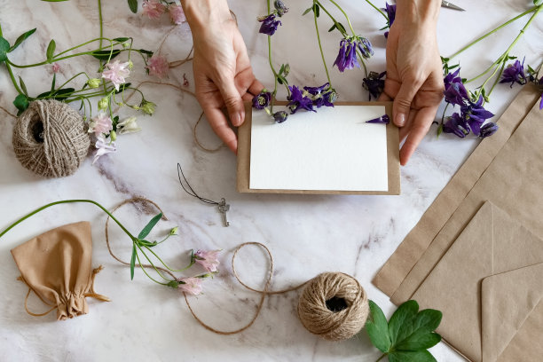 大理石办公桌，粉红色和蓝色的花，明信片，牛皮纸信封，麻绳，棉花树枝。布局妇女节或母亲节、情人节，平放位置，俯视图。图片下载