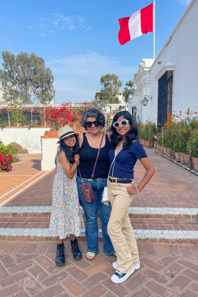 母亲和两个女儿在国旗前摆姿势拍照图片下载