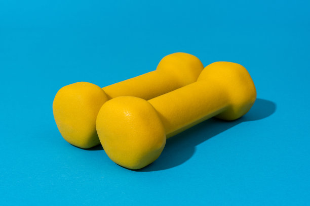 蓝色背景上的黄色健身哑铃照片图片下载