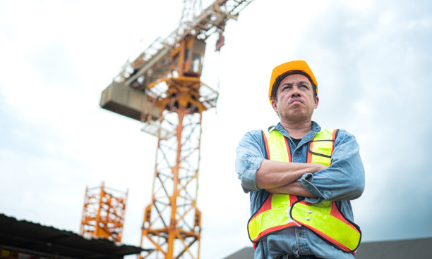 起重机工人肖像使用对讲机与塔式起重机操作员通信，以提升和移动建筑工地上的物体图片下载