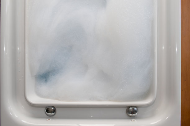 按摩浴缸里的白色泡泡是为度假村舒适客房里的私人按摩浴缸准备的泡泡。大量的小气泡背景和复制空间插入文本。图片下载