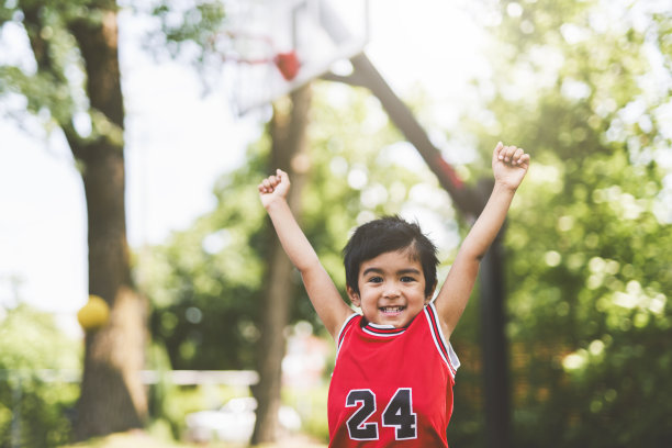 一个男孩在公园里打篮球的照片图片下载
