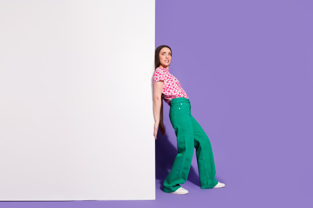 可爱的年轻女士的全身照片强调墙壁的空白空间穿着时髦的粉红色服装孤立在紫罗兰色的背景图片下载