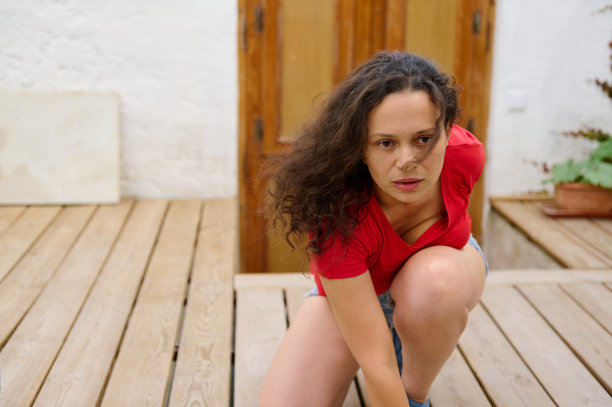 穿红衬衫的女人在户外的木甲板上紧张地准备着图片下载