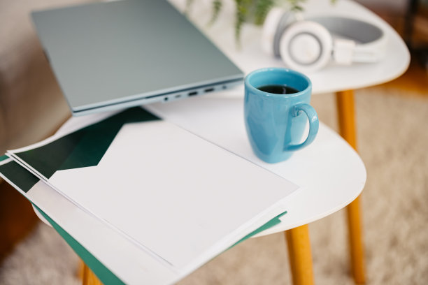 白纸文件，一杯咖啡，笔记本电脑和耳机放在咖啡桌上图片下载