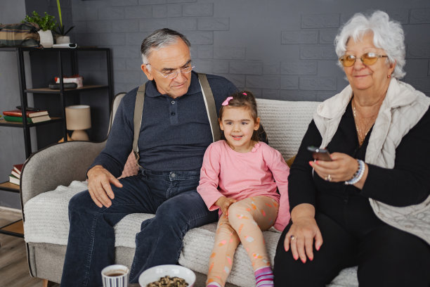 爷爷奶奶正在和他们可爱的孙女一起看电视图片下载