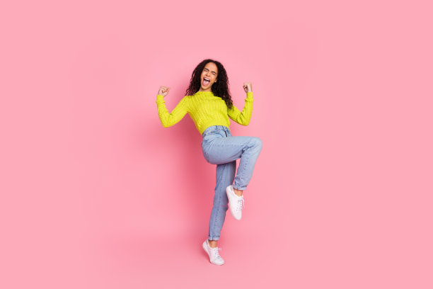 年轻女孩的全身长照片与卷曲的黑发摆姿势休闲服装模特机构广告孤立的粉红色背景图片下载