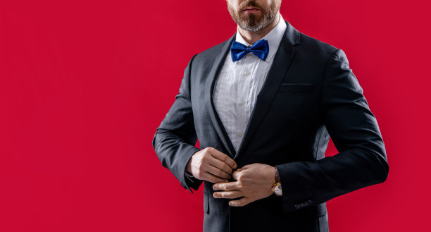 穿燕尾服的人孤立在红色背景上，复制空间。西装男在演播室。身穿燕尾服的男子照片图片下载