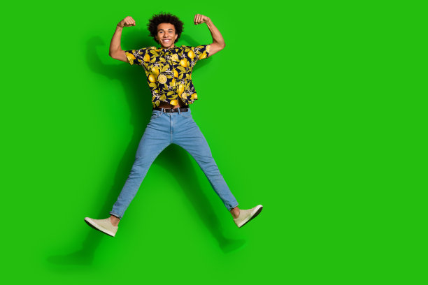 照片中乐观积极的男人穿着时髦的夏季印花衣服，手臂二头肌空白空间孤立在绿色背景上图片下载