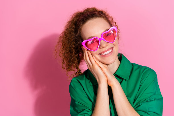照片中迷人积极的女人穿着绿色衬衫心眼镜微笑空空间孤立粉红色背景图片下载
