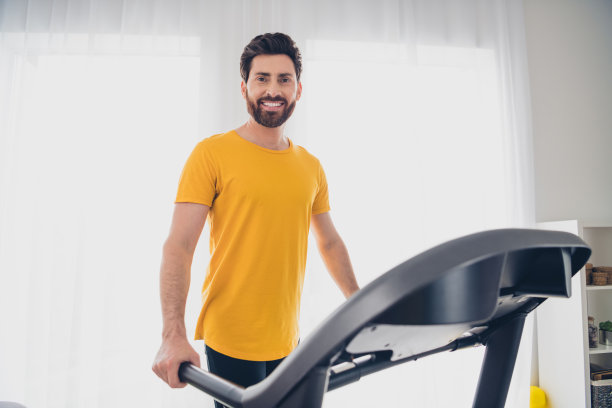 有吸引力的开朗强壮的男人在家庭健身房室内练习跑步机的照片图片下载
