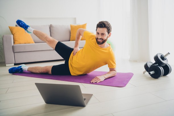 快乐的运动员做运动的照片，抬起一条腿，在垫子上工作，在家室内训练，家庭健身房图片下载