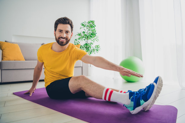 时髦酷的家伙穿着黄色t恤在室内练习家庭训练的照片图片下载