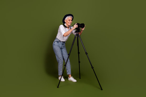 全程照片的专业正面女摄影师穿白衬衫帽子钉照片空白空间孤立的绿色背景图片下载