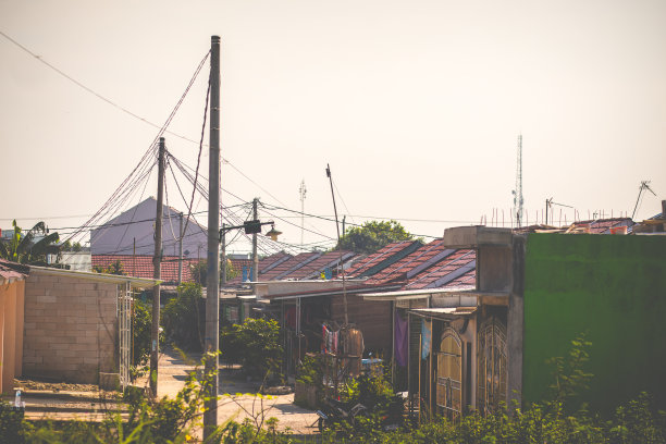 位于印度尼西亚的一排带有屋顶瓦片和电线杆元件的房子的照片。屋顶瓦片的房子照片在一个阳光明媚的日子里图片下载