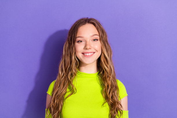 照片肖像迷人的少女愉快的牙齿微笑穿着时尚的绿色衣服孤立的紫色背景图片下载
