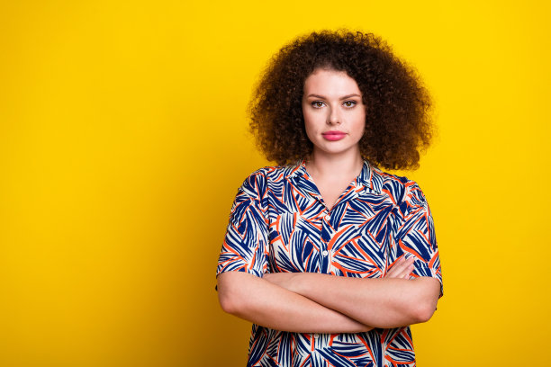 照片肖像可爱的年轻女士交叉双手自信地穿着时尚的彩色服装孤立的黄色背景图片下载
