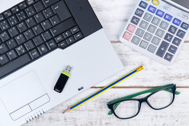 正上方的照片是戴着眼镜的笔记本电脑和白色桌子上的文具图片下载