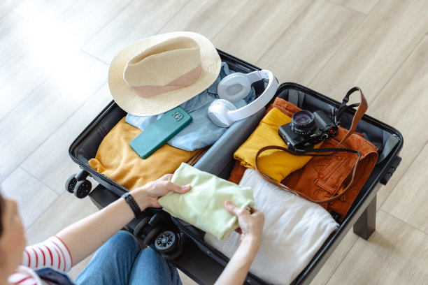 一个无法辨认的女人把衣服放进行李箱的剪短照片图片下载