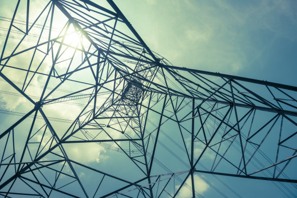 以单色背光阳光天空为背景的高压杆状输电塔底图的抽象图案。图片下载