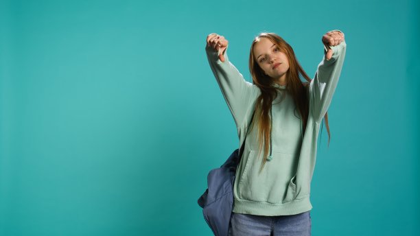 沮丧的女人在做拇指朝下的手势图片下载