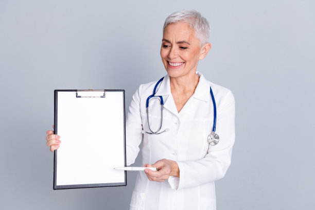 照片迷人迷人的专业医生外科医生女人穿着白色大褂拿着医疗保险孤立在灰色背景图片下载