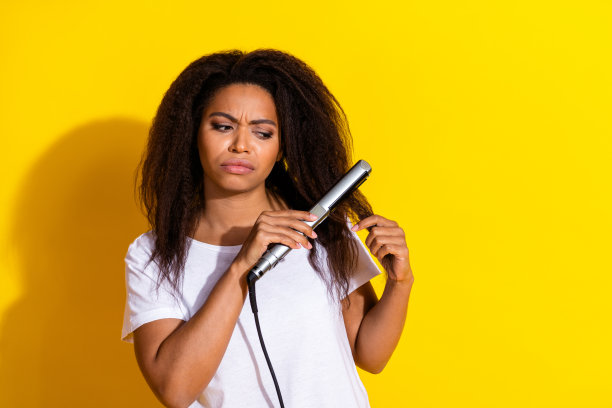 照片的漂亮年轻女子头发拉直穿t恤孤立的黄色背景图片下载