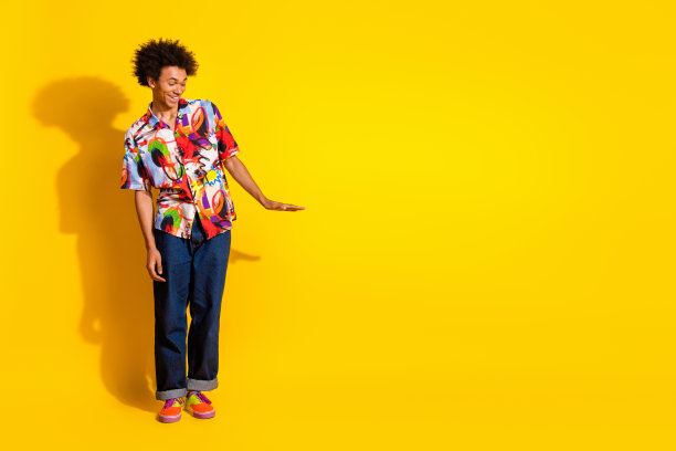 漂亮时髦的年轻人的全尺寸照片手臂测量空的空间穿衬衫孤立在明亮的黄色背景图片下载