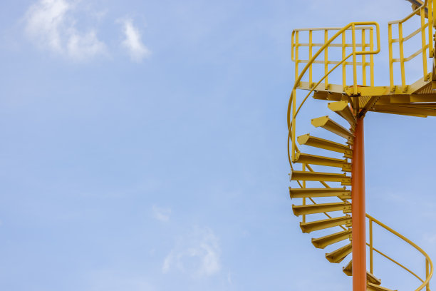 在蓝天的映衬下，可以看到一个螺旋形楼梯图片下载